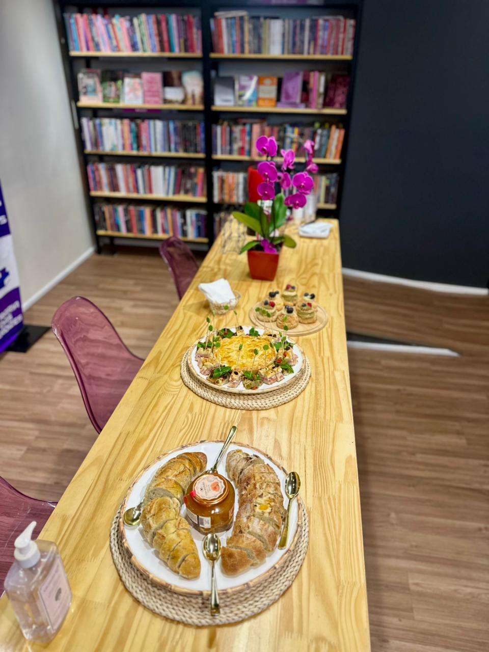 Mesa posta do encontro, com pães, doces e flores